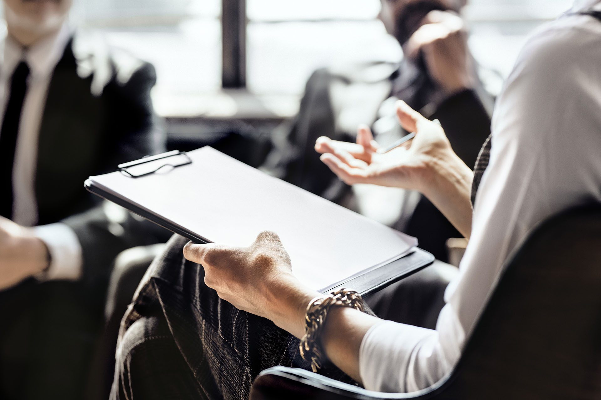 person sitting holding clipboard